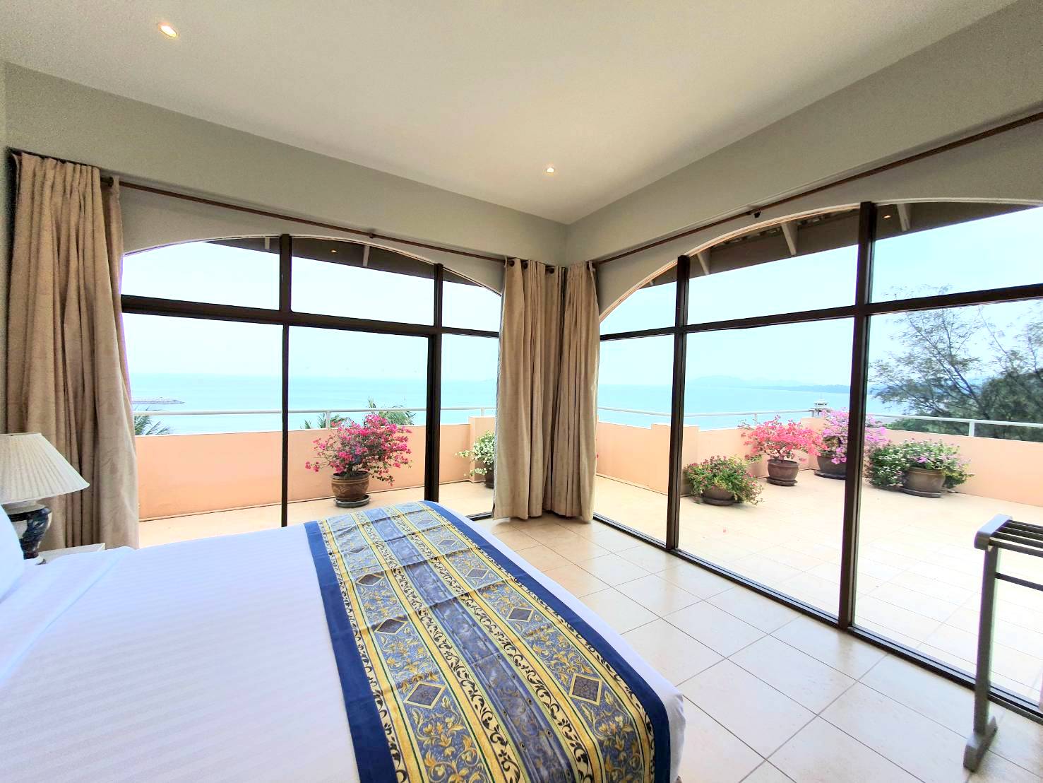 One bedroom with a king size bed, large furnished terrace with plants and flowers facing the sea, separate living room, bathroom with shower.